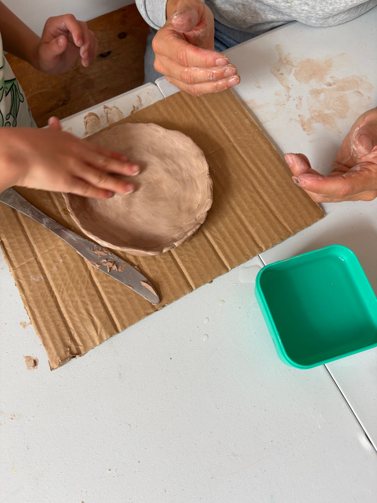 Ouder en kind werken samen met klei